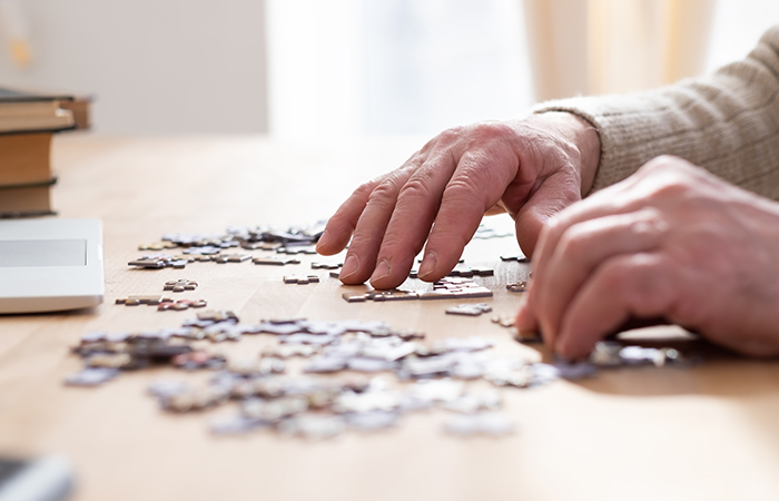 Hands putting together a puzzle on a table